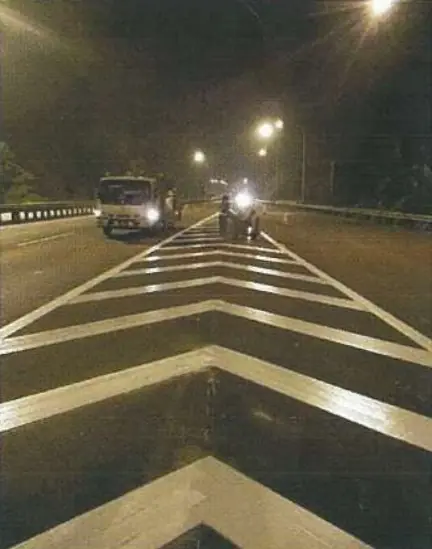 White thermoplastic chevron hatching applied on a highway at night